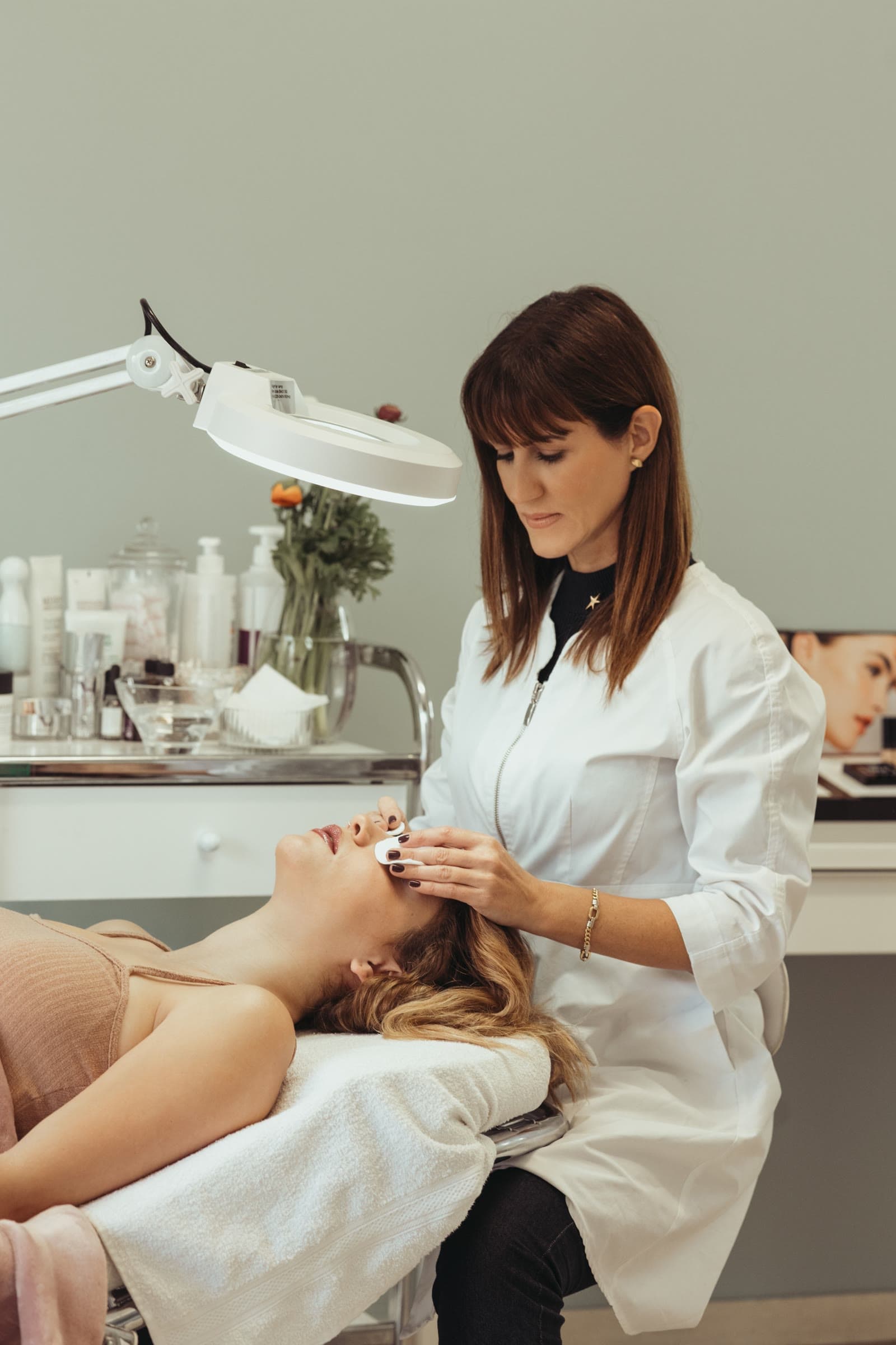 Esthetics specialist serving a client in a premium facial care space